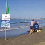 Persona in spiaggia in carrozzina