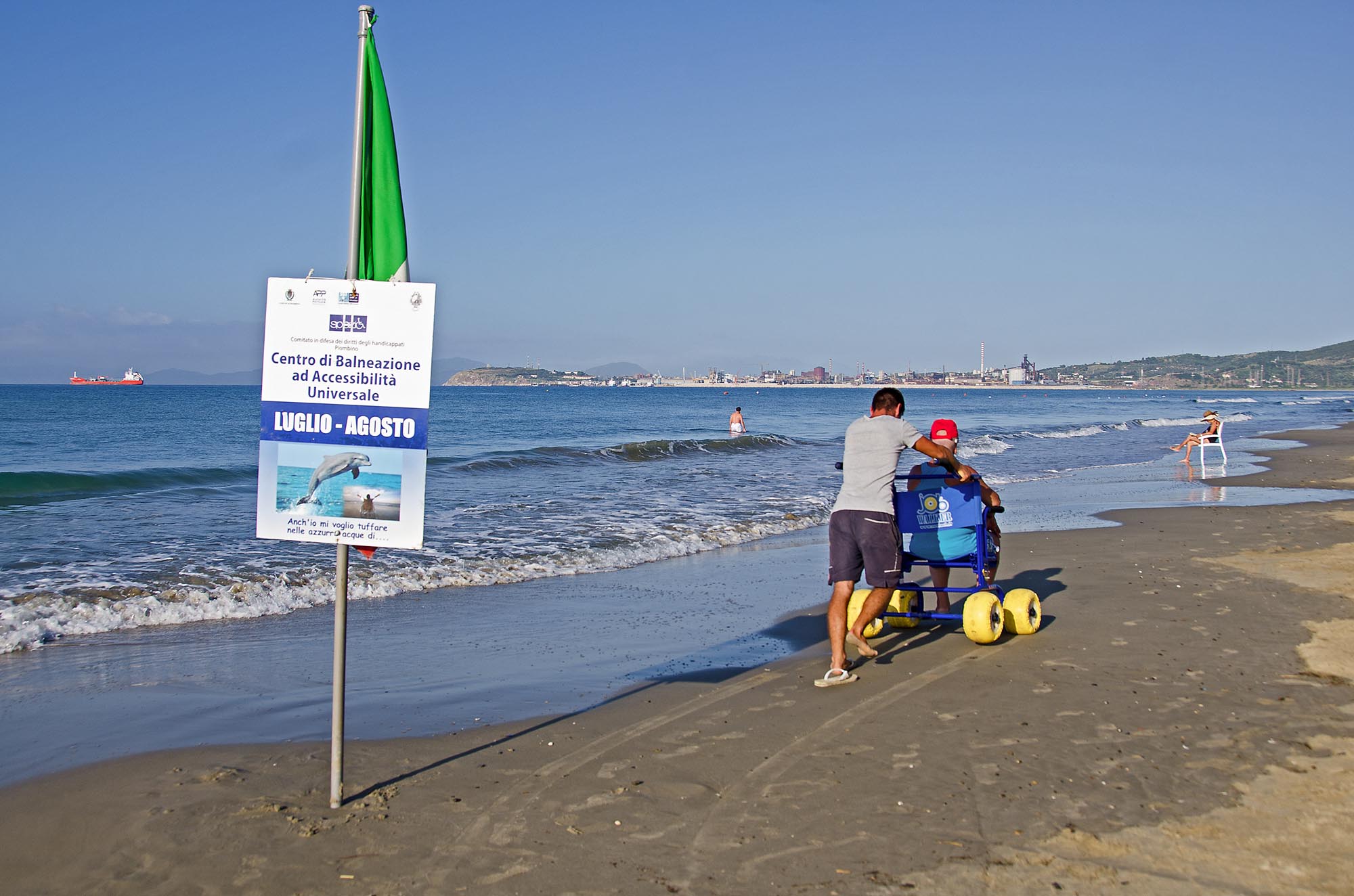 Persona in spiaggia in carrozzina