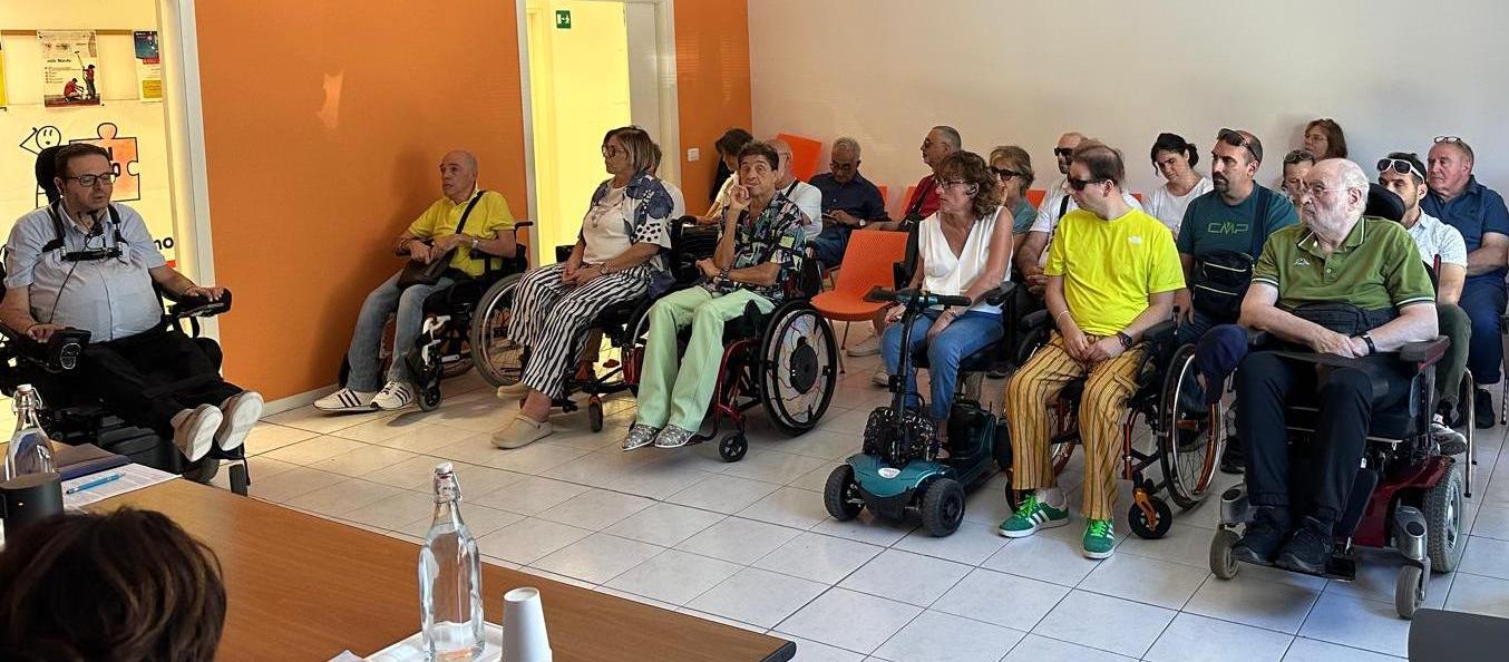 Persone in in carrozzina in una sala