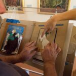 Due persone sfogliano un libro per ipovedenti.