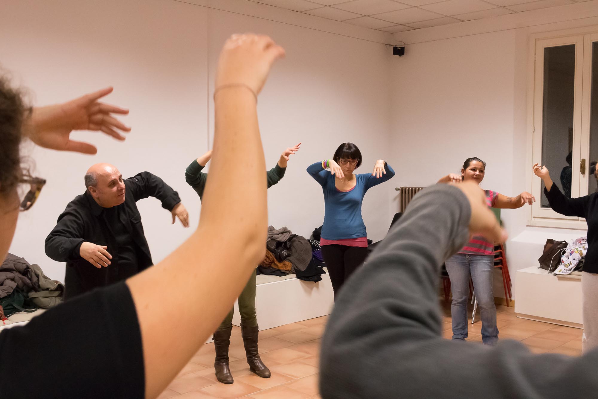 Persone in una stanza che volteggiano le braccia