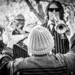 due persone suona la tromba, una persona balla