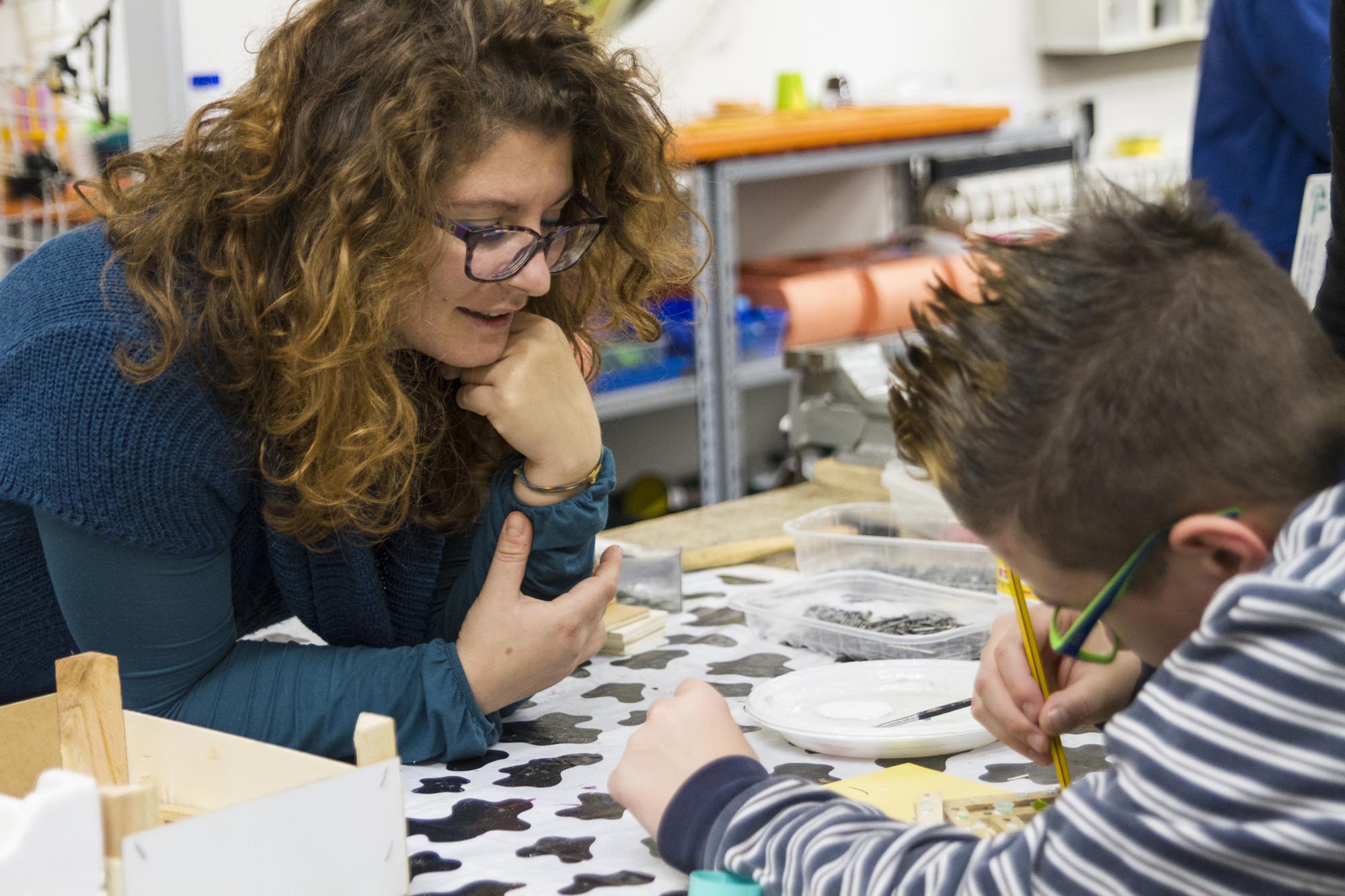 Una donna e un bambino al tavolo con dei pennelli