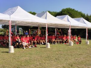 tensostruttura bianca che ospita numerosi giovani seduti su panche