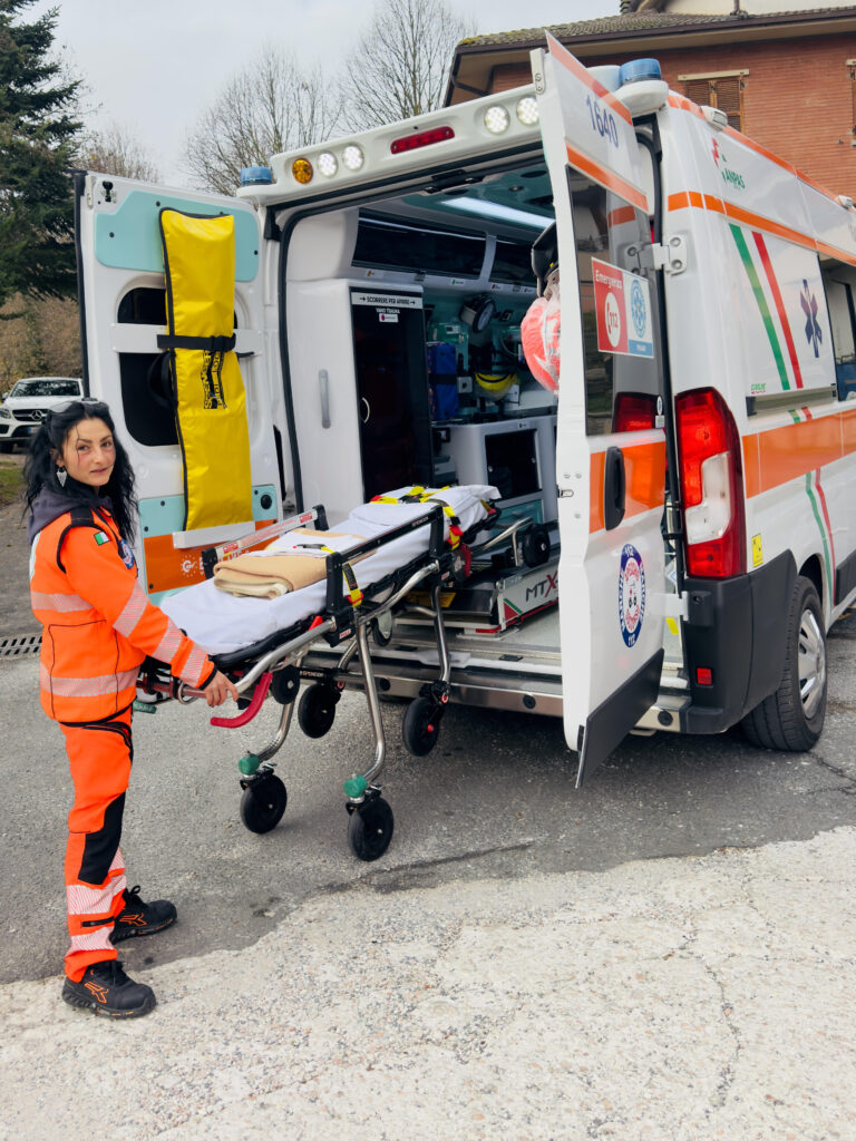 Letizia Landi regge una barella vicino a un'ambulanza