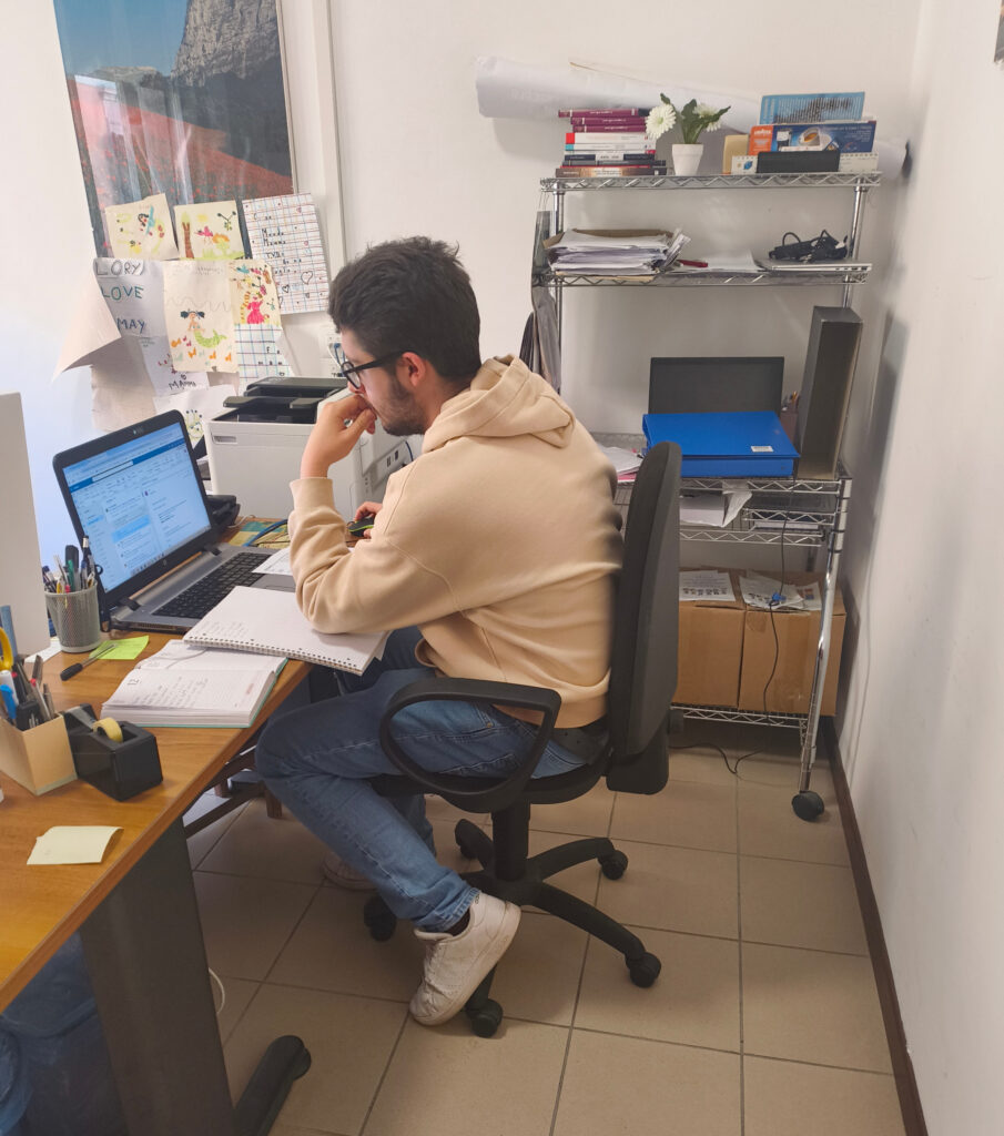 Foto di Luca Manganelli seduto davanti a una scrivania