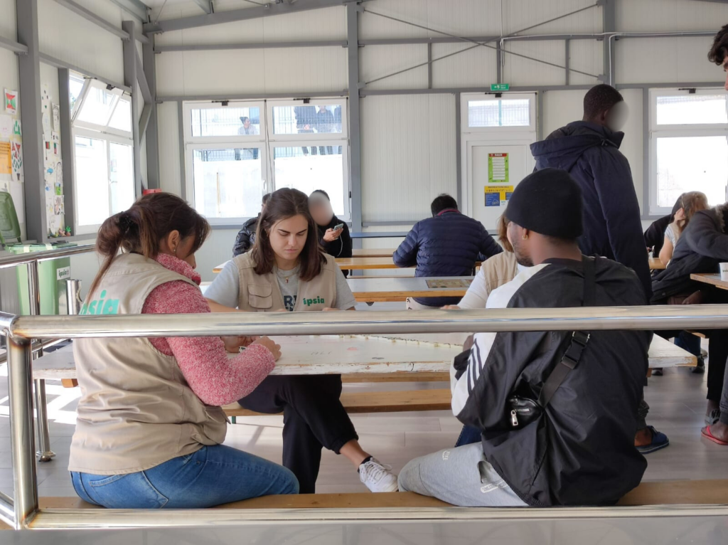 Elisabetta Figini con altri volontari insieme ad alcuni migranti