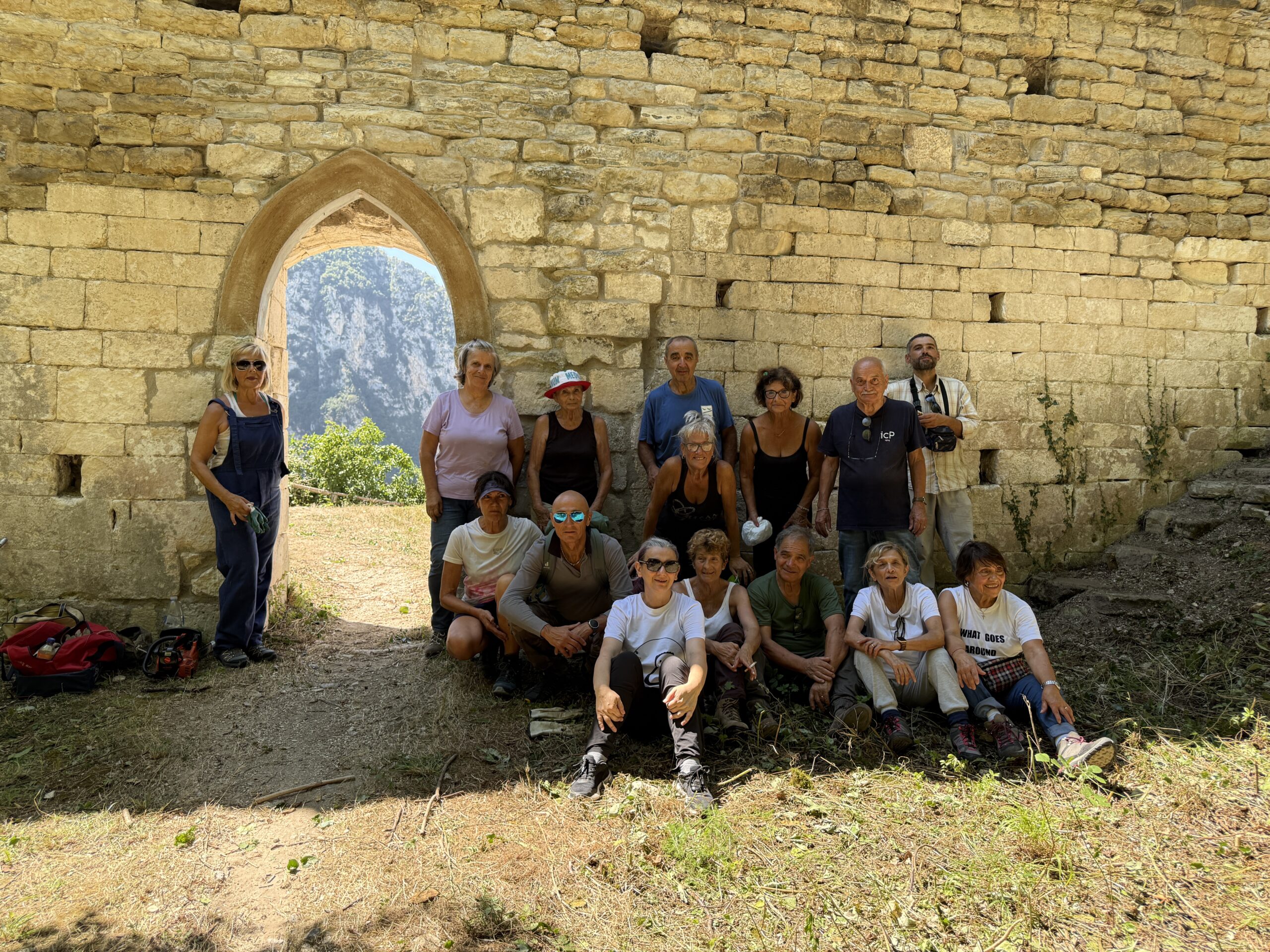 Gruppo di persone in posa da fotografie davanti a un eremo