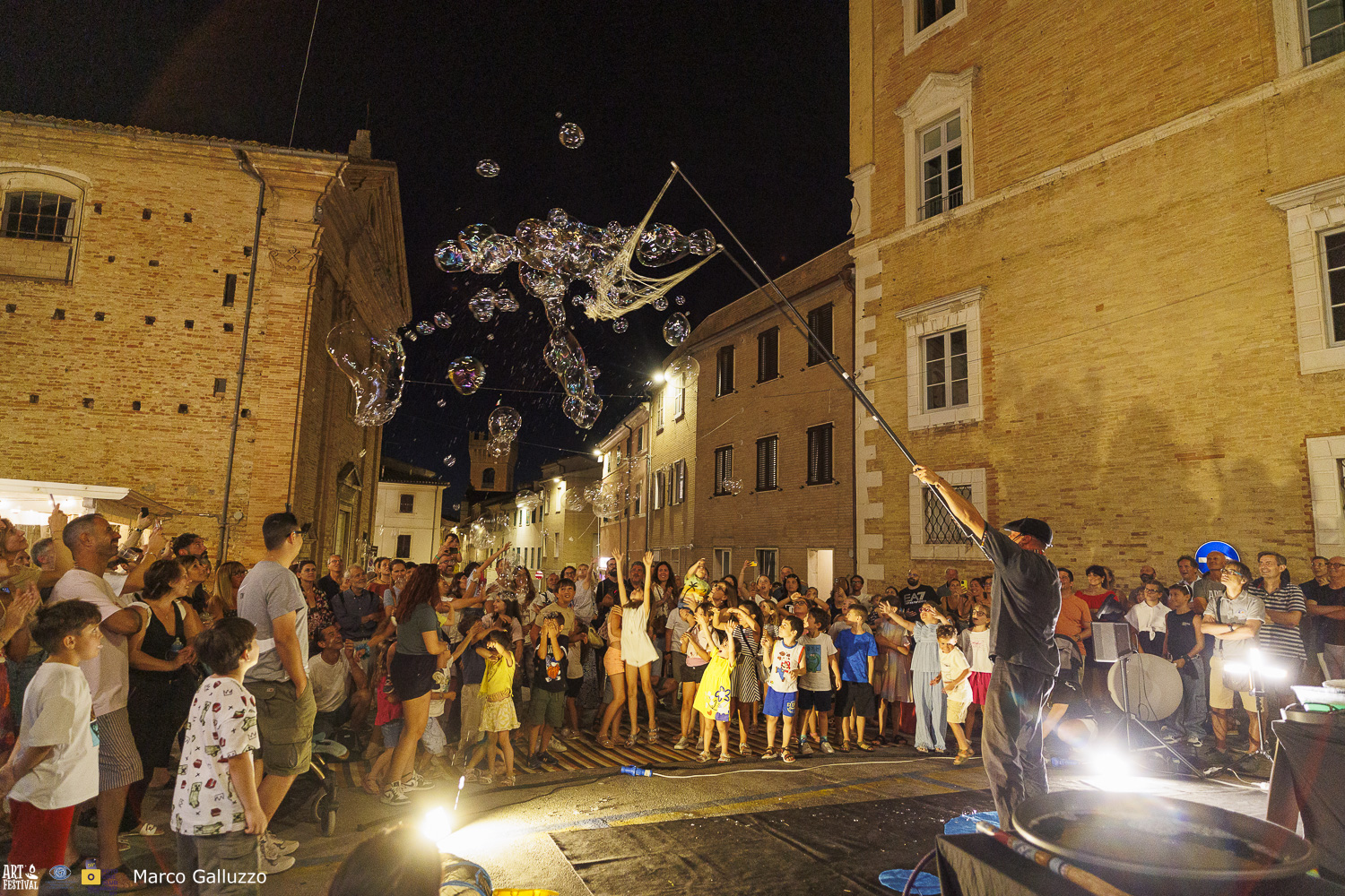 Persone in piazza con bolle di sapone in cielo