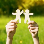 due mani sostengon il profilo stilizzato di due umani