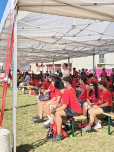 plate di giovani con t shirt rossa sotto una tensostruttura