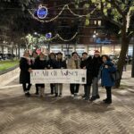 persone dietro a uno striscione in piazza