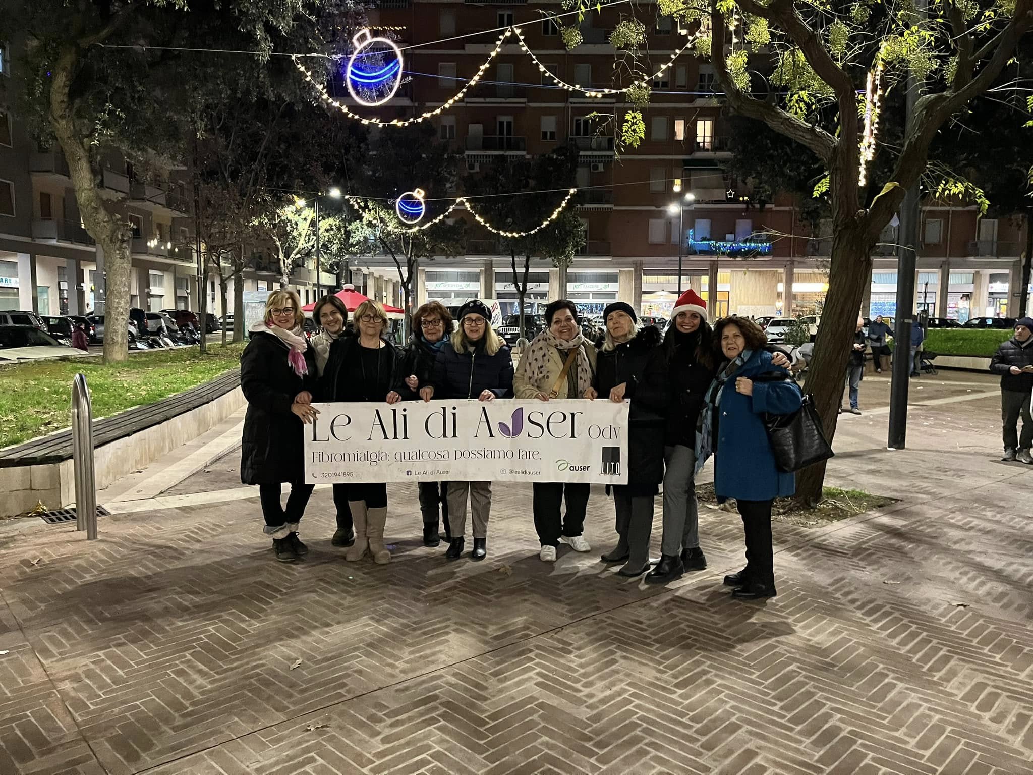 persone dietro a uno striscione in piazza
