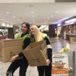 Due ragazze trasportano un cartone