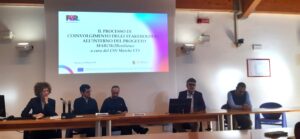 tavolo con 5 relatori durante l'intervento di uno 