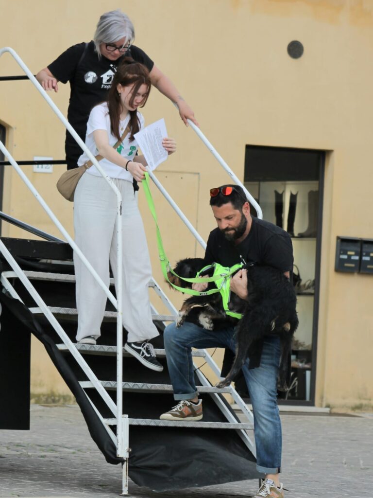 Foto di Noemi Saracini e di altri due volontari con un cane nero