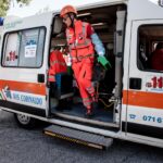 un volontario in divisa fluorescente scende da una ambulanza