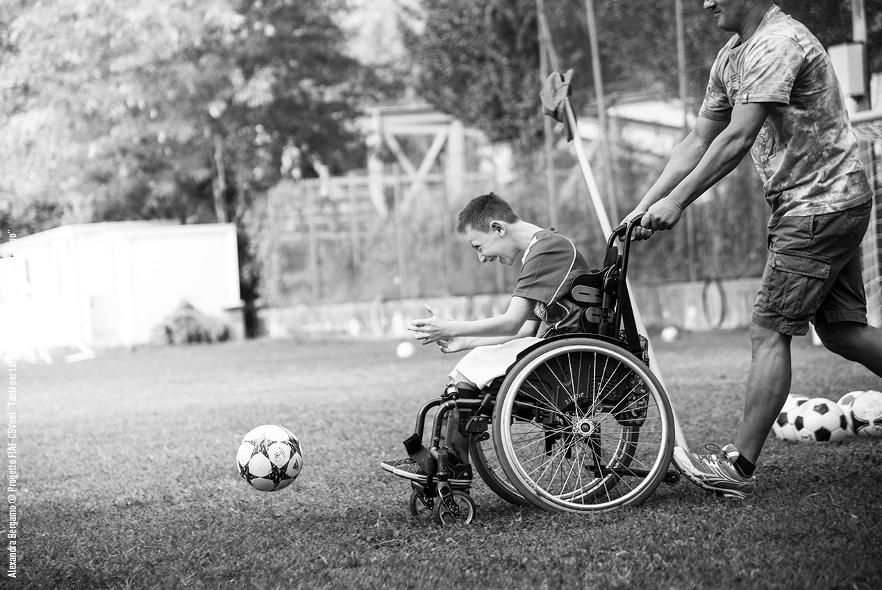 una persona in sedia a rotelle che insegue un pallone