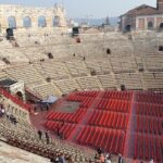 l'interno dell'arena di verona con la platea riempita da sedie e le gradinate in pietra