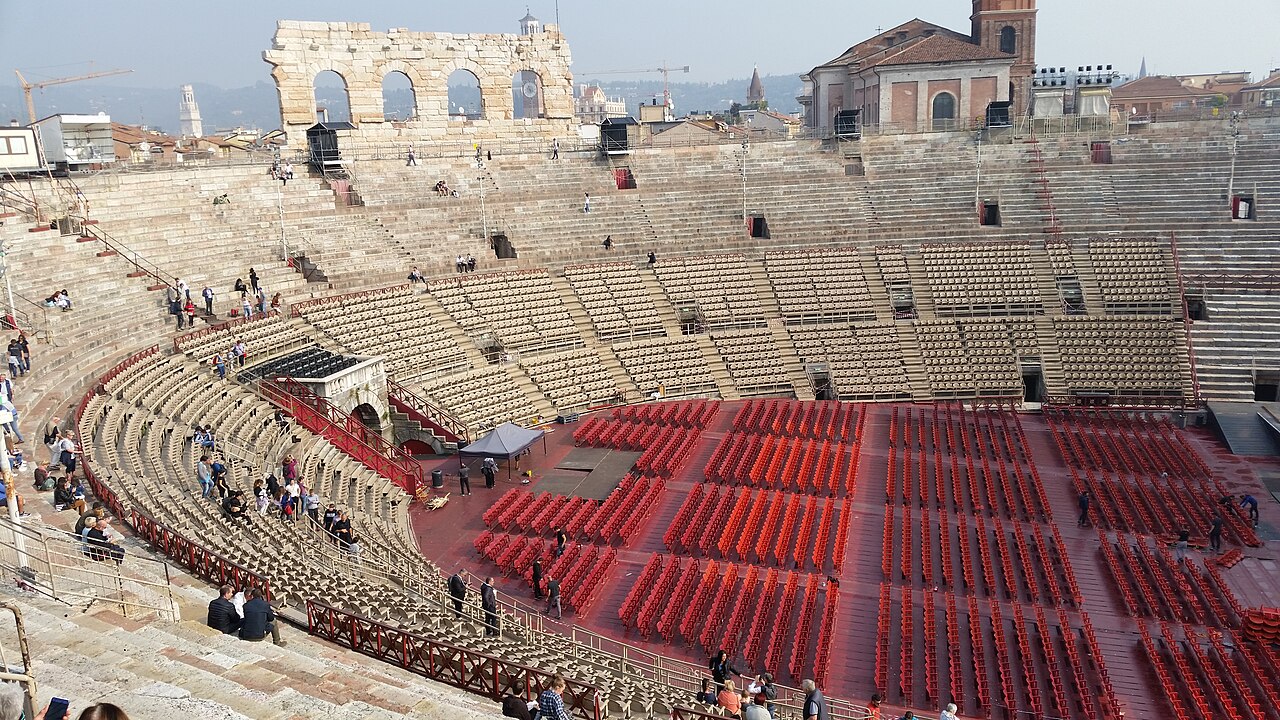 l'interno dell'arena di verona con la platea riempita da sedie e le gradinate in pietra