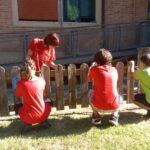una squadra di giovani partecipanti al progetto mentre dipingono una staccionata
