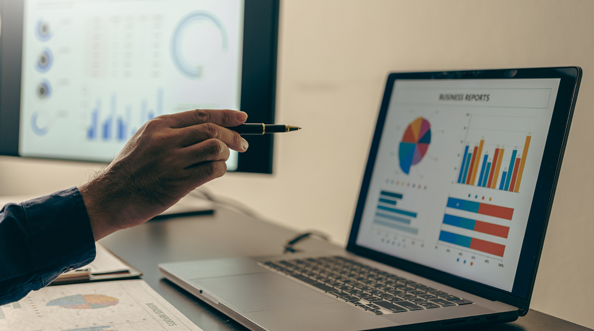 una mano indica un grafico sullo schermo di un pc