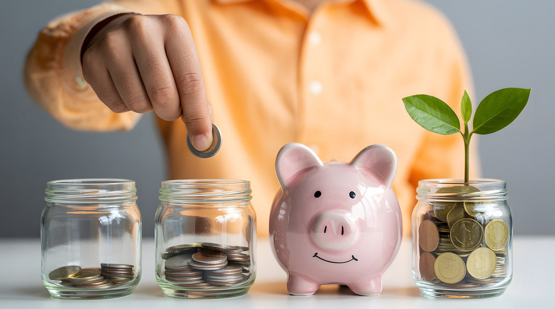 una persona inserisce una moneta nel secondo di quattro vasetti/salvadanai in fila davanti a sè