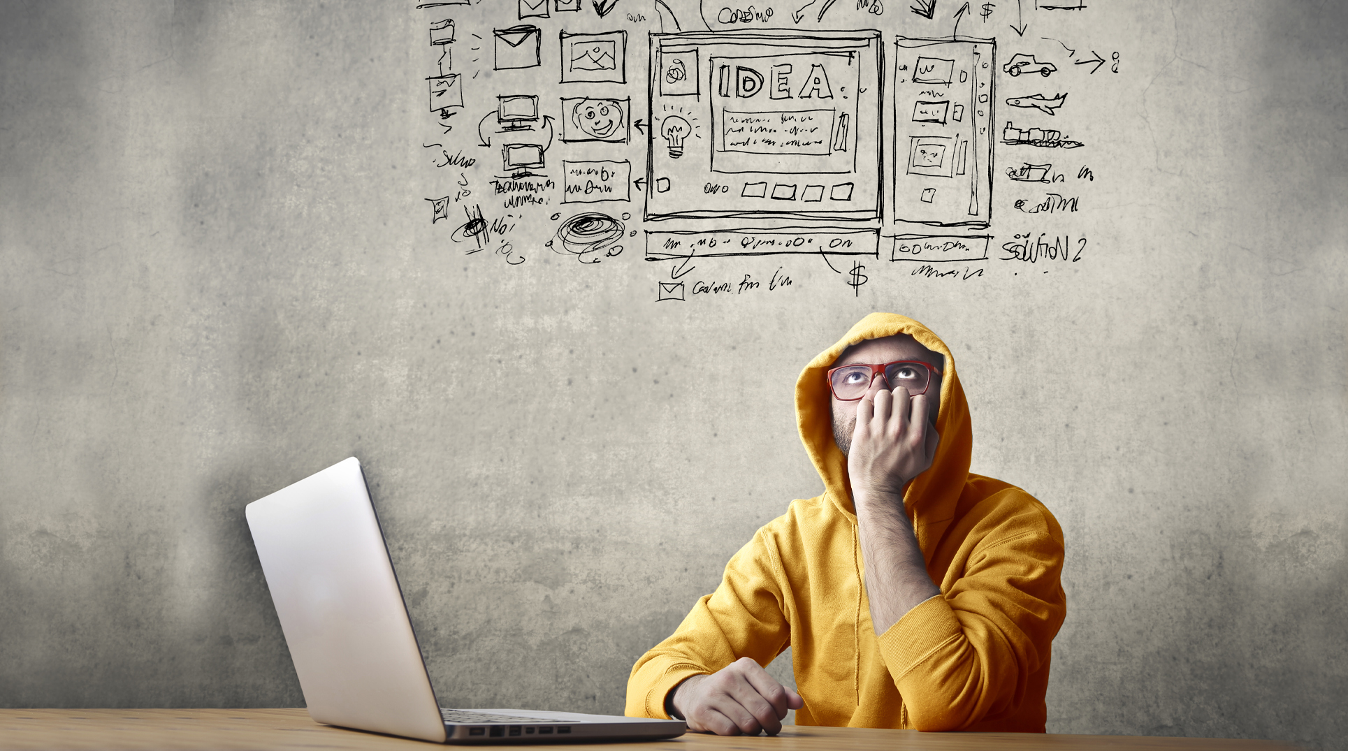 un ragazzo dubbioso davanti a un pc immagina il lavoro da fare per un sito web