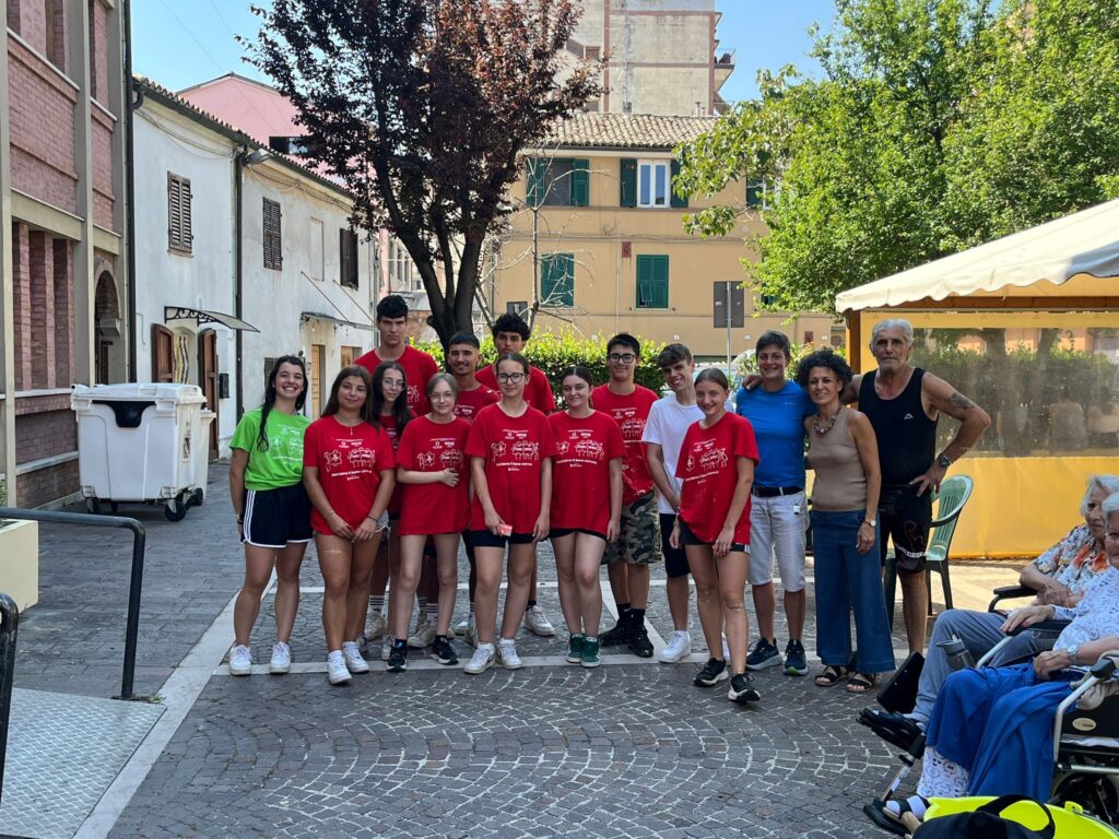 gruppo di giovani con tshirt rossa in una piazzetta di Chiaravalle