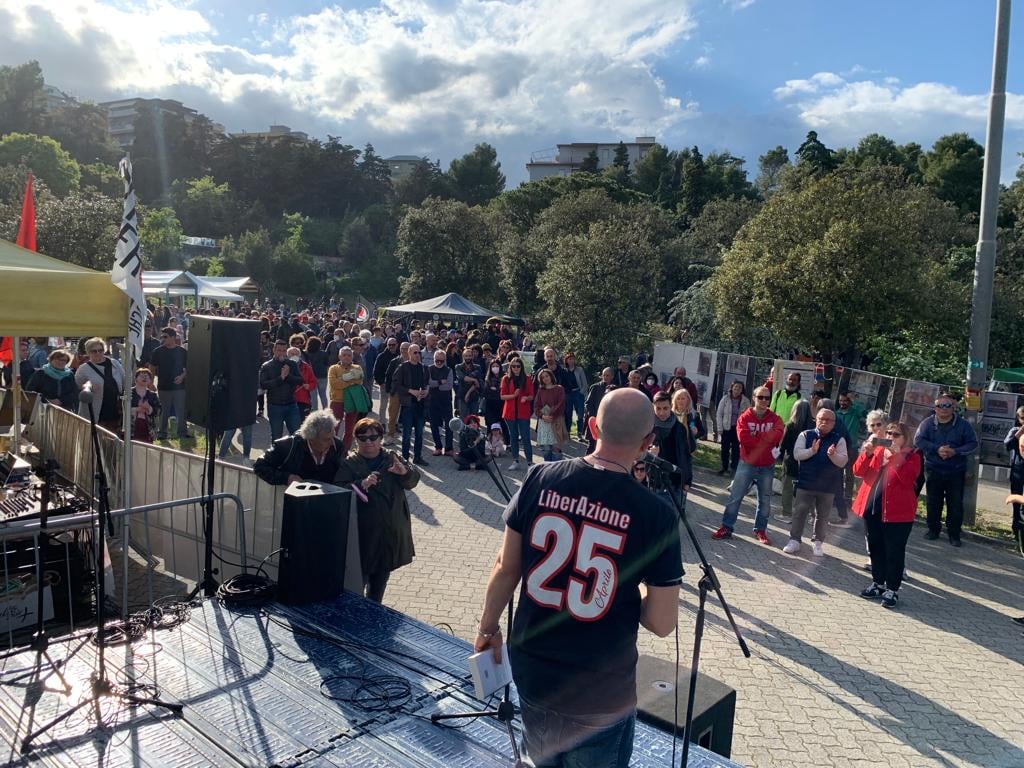 Un palco con una persona al microfono e il pubblico davanti