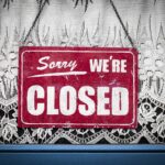 un cartello appeso alla porta riporta "Sorry, we're closed"