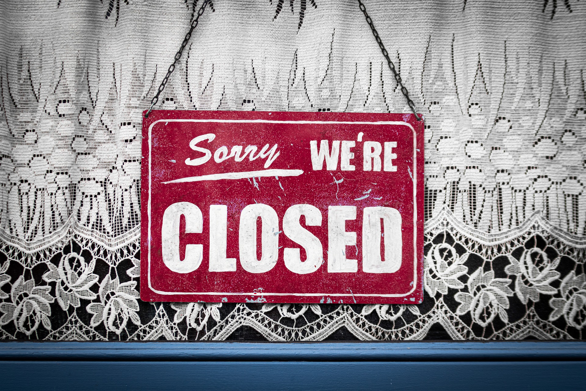 un cartello appeso alla porta riporta "Sorry, we're closed"