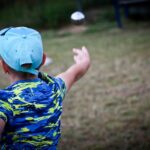 un bambino di spalle lancia un fresbee