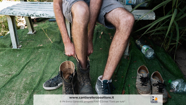 Un uomo si infila le scarpe