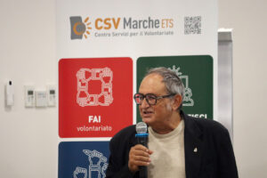 un uomo al microfono durante una riunione