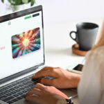 una donna al pc portatile sta navigando sull'Hub Terzo settore Marche