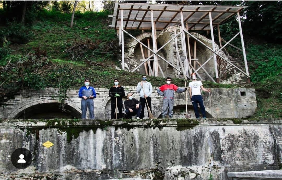 Quattro persone al lavoro davanti a una struttura in restauro