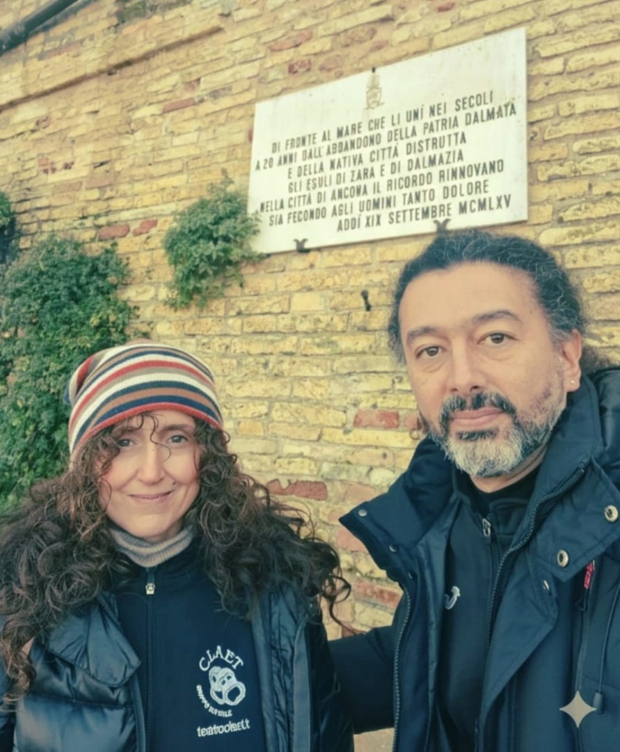 Due persone davanti a una lapide.