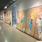 Un corridoio con opere figurali esposte