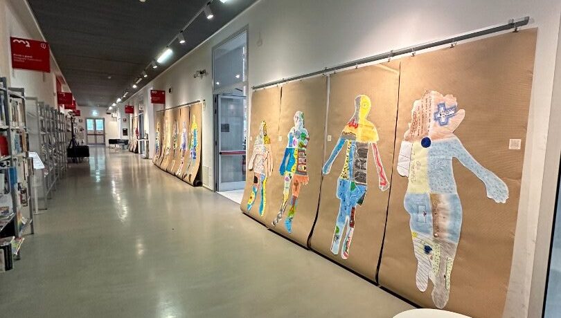 Un corridoio con opere figurali esposte