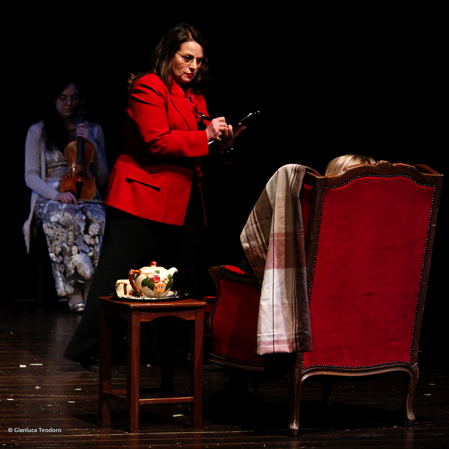 Una donna in piedi davanti a una persona in poltrona