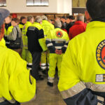 Un gruppo di volontari della protezione civile Marche in divisa, ritratti di spalle