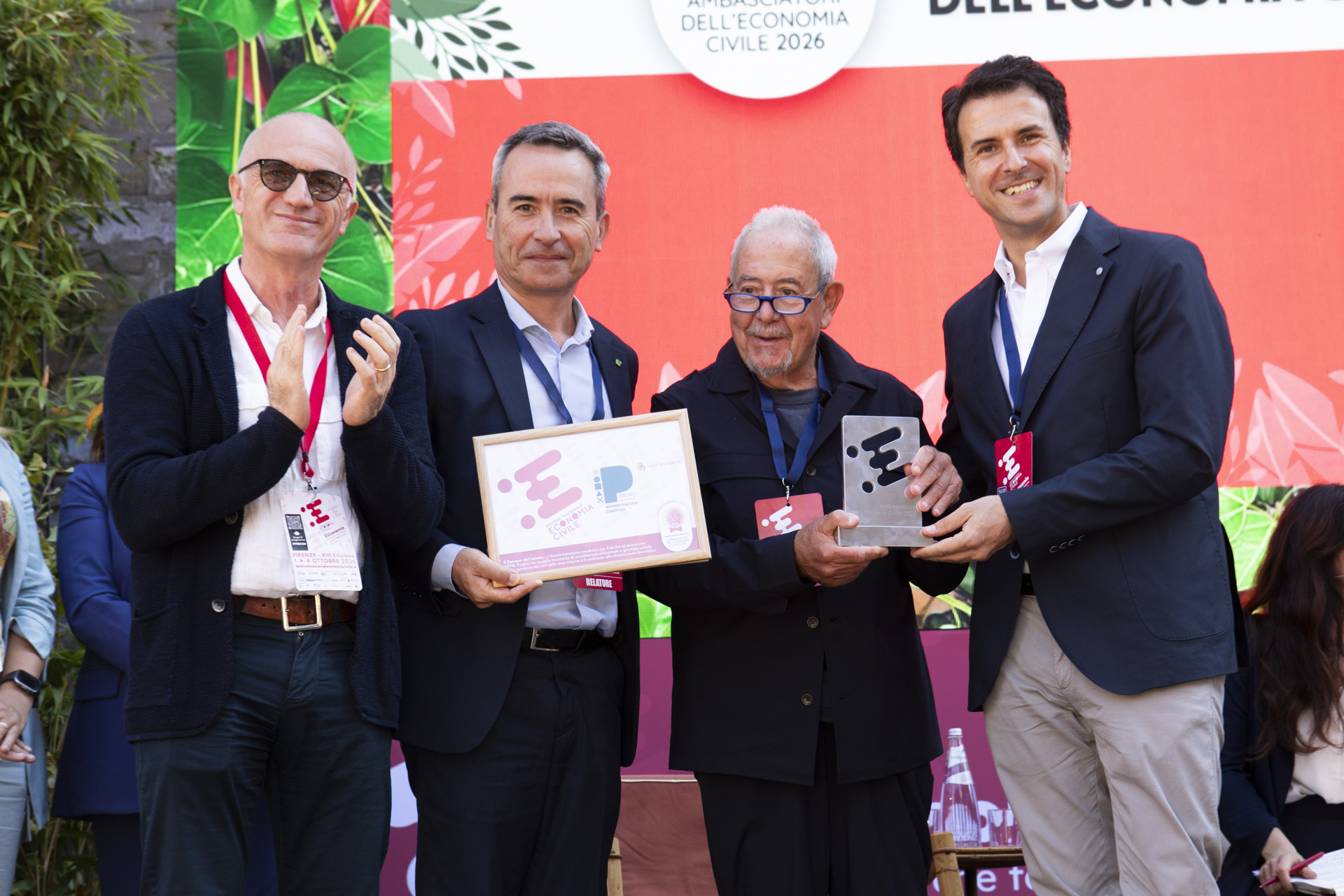 quattro persone sul palco mentre ricevono un premio