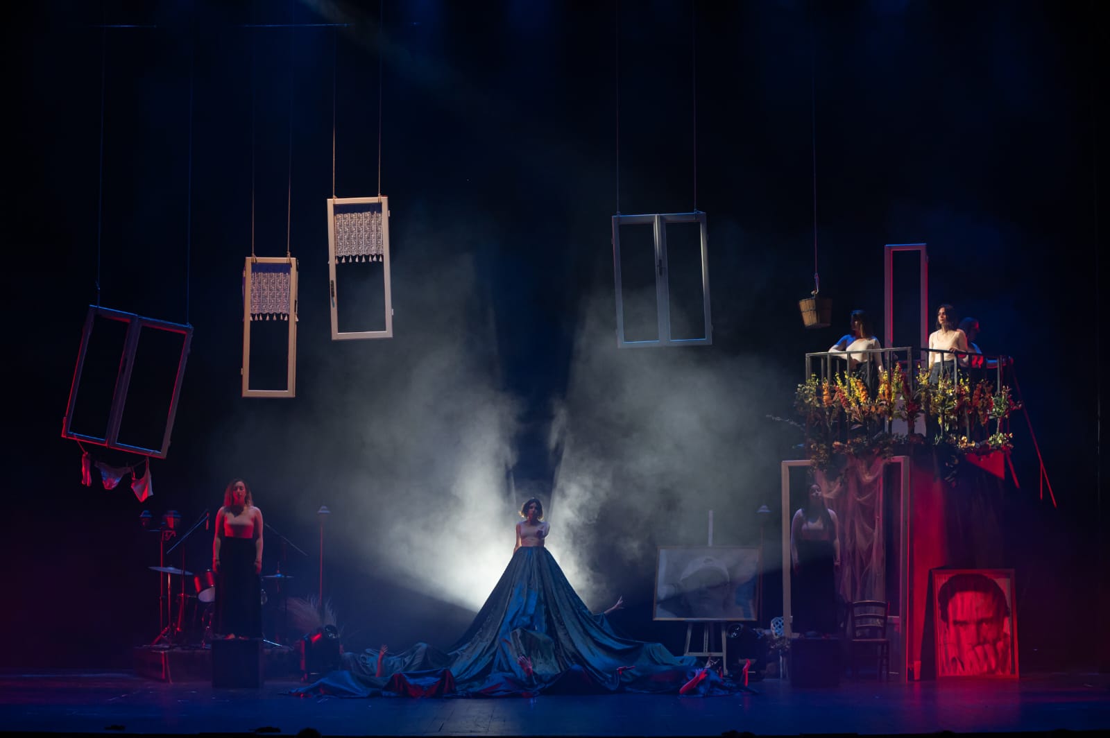 cinque attrici sul palcoscenico di un teatro, circondate da quadri, infissi e da un balconcino