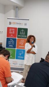 donna interviene al microfono durante un'assemblea