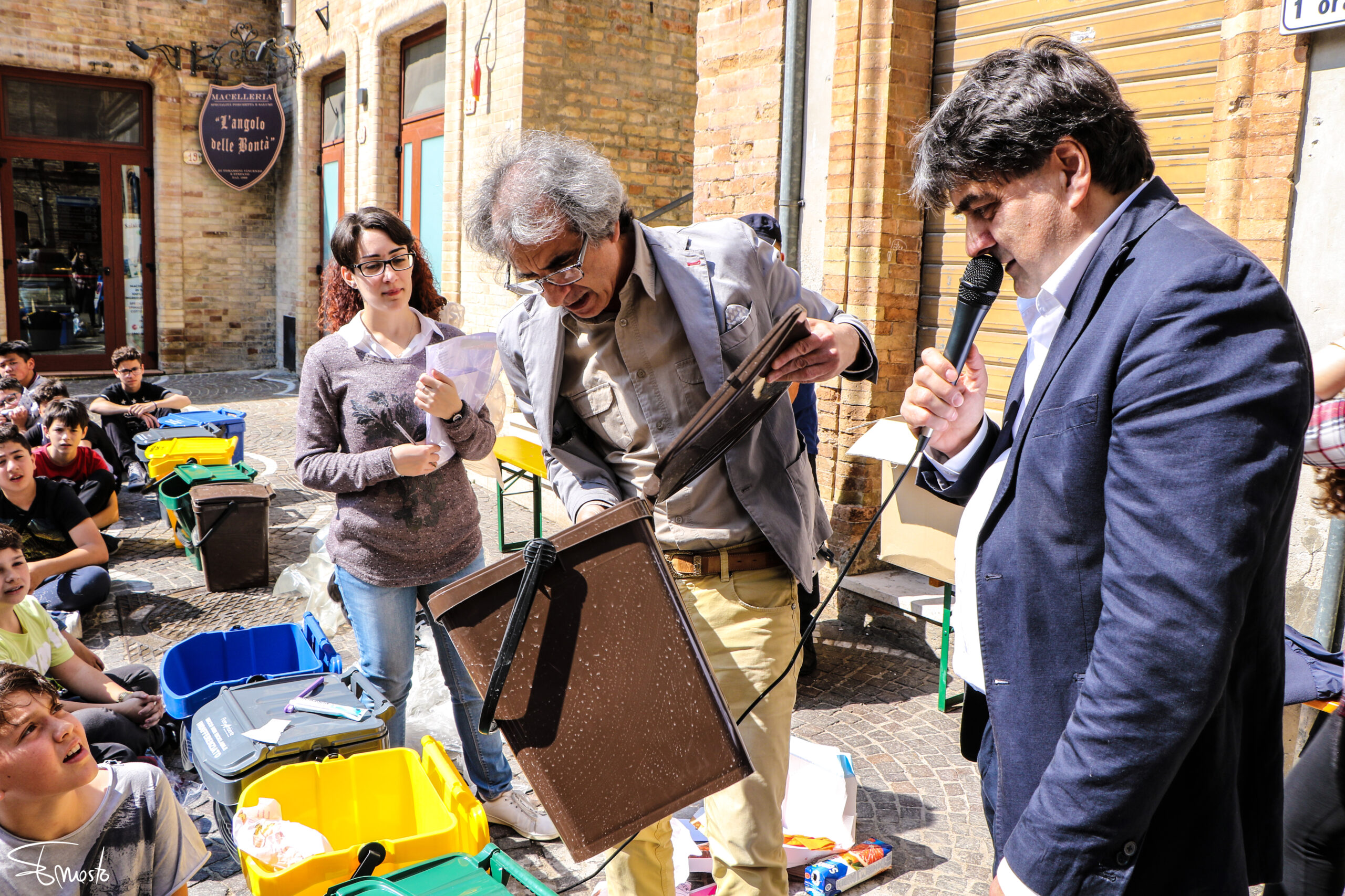 Un uomo esamina un bidone dell'umido