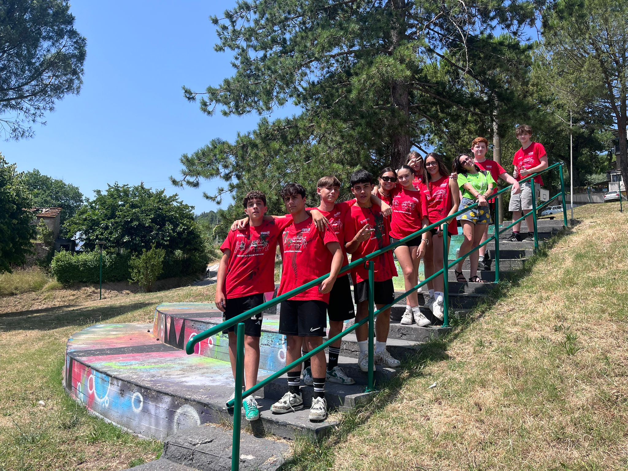 squadra di giovani con le tshirt rosse in posa lungo la scalinata di un parco