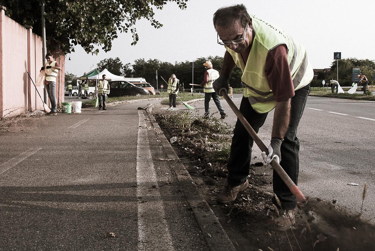 Una persona che lavora in una strada con un badile
