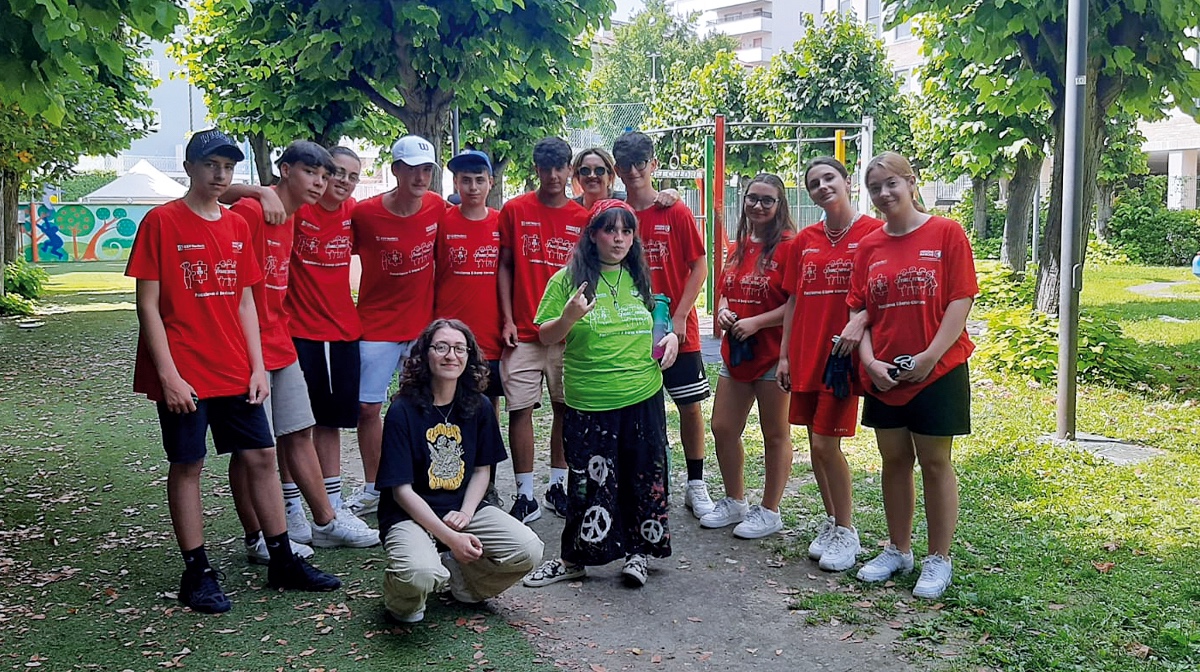 squadra di giovani partecipanti con tshirt rossa, insieme alla tutor