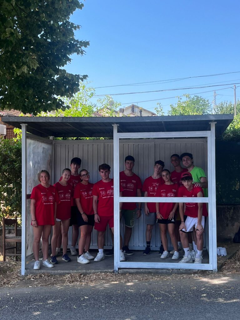 Foto di Alessandro Marchetti (maglia verde) con la seconda squadra del progetto Ci sto affare fatica, sotto una pensilina ripulita